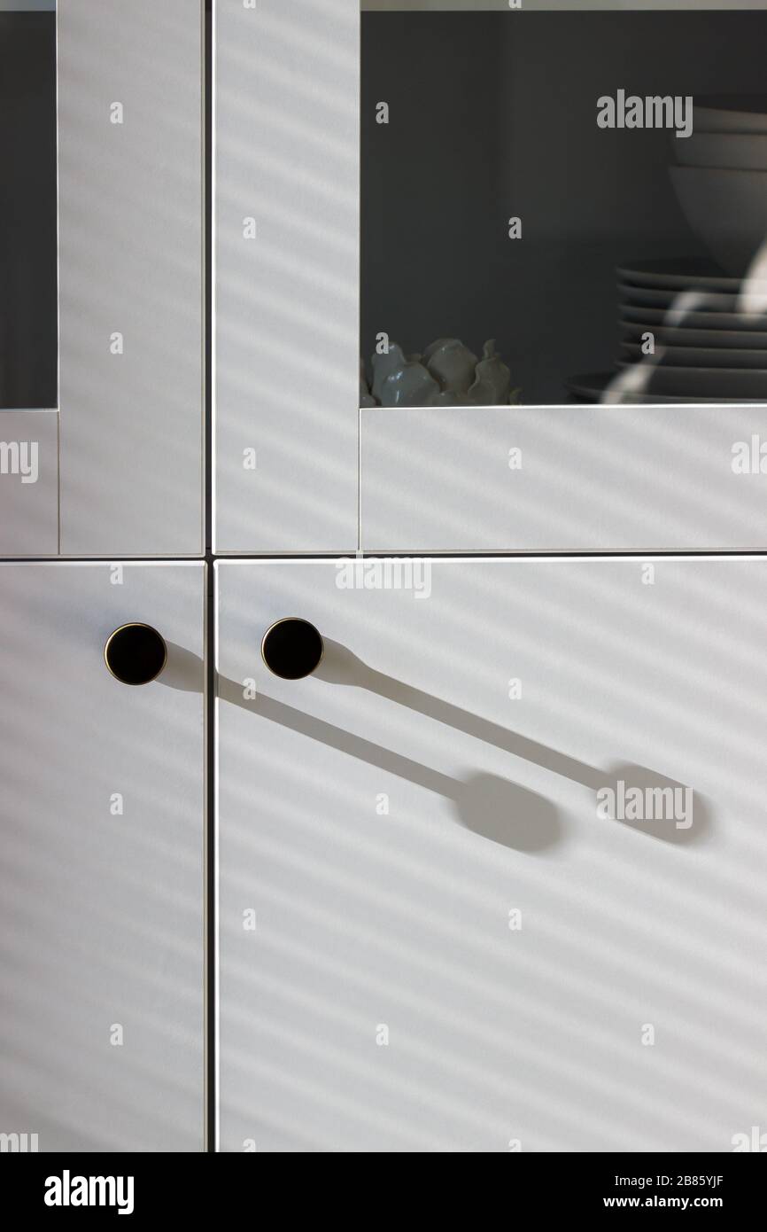 Ombres dures et douces sur une armoire blanche avec ustensiles. Banque D'Images