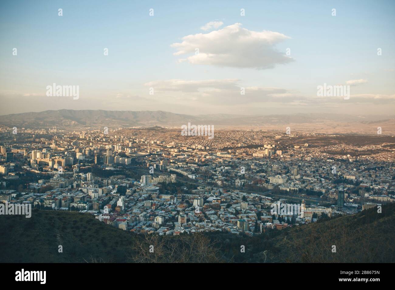 Belle vue panoramique de Tbilissi, Géorgie. La ville près des montagnes contre le ciel avec des nuages. Banque D'Images