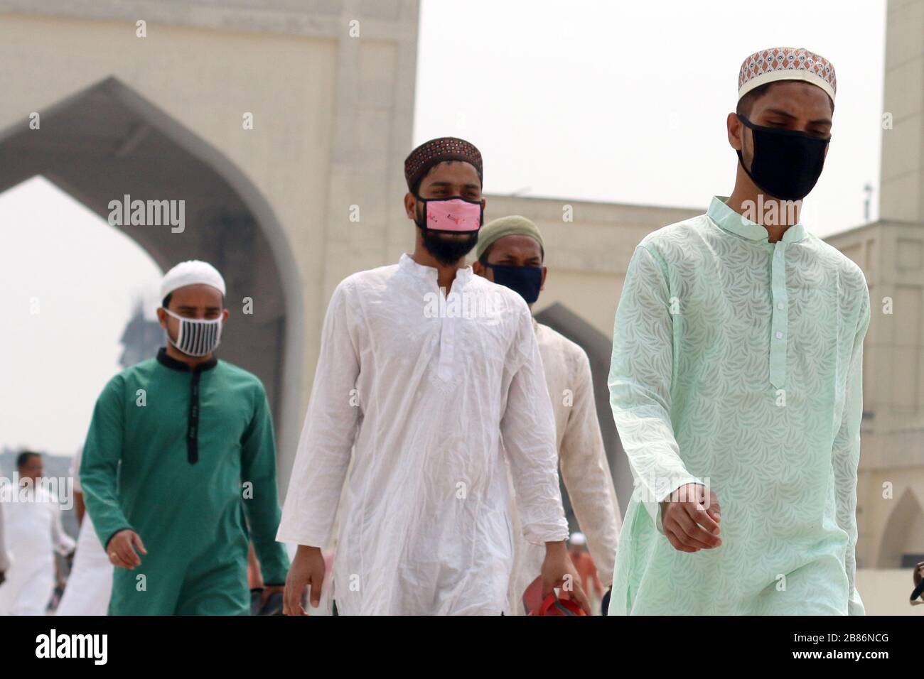 Les musulmans arrivent pour les prières du vendredi (Jummah) tout en portant des masques de protection comme mesure préventive contre la propagation du Coronavirus à la Mosquée nationale de Dhaka. Banque D'Images