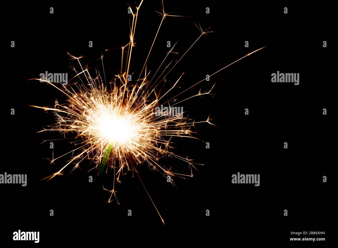 Gros plan sur un sparkler éclairé dans l'obscurité avec un espace de copie sur la droite. Banque D'Images