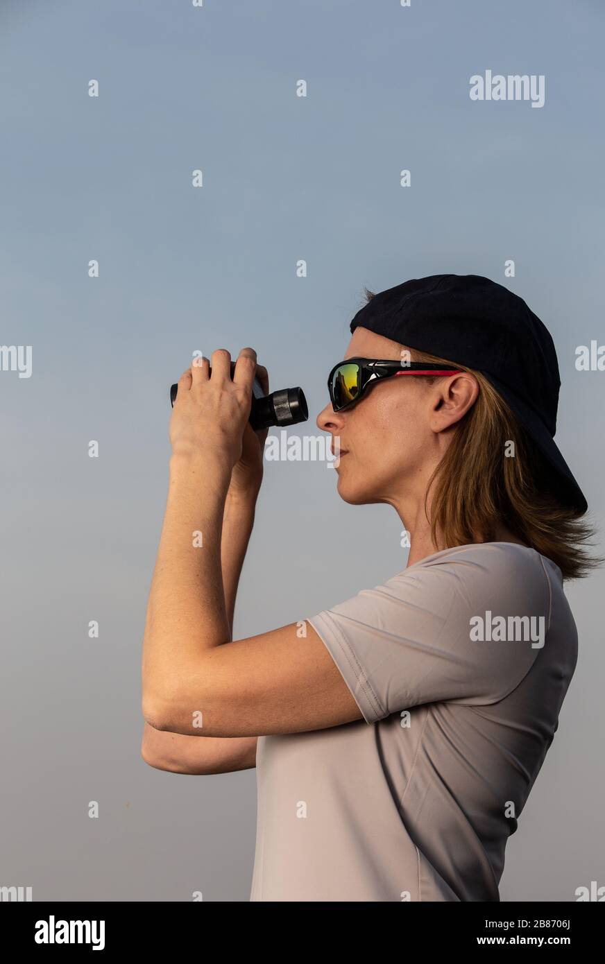 femme avec basecap et lunettes de soleil et jumelles Banque D'Images