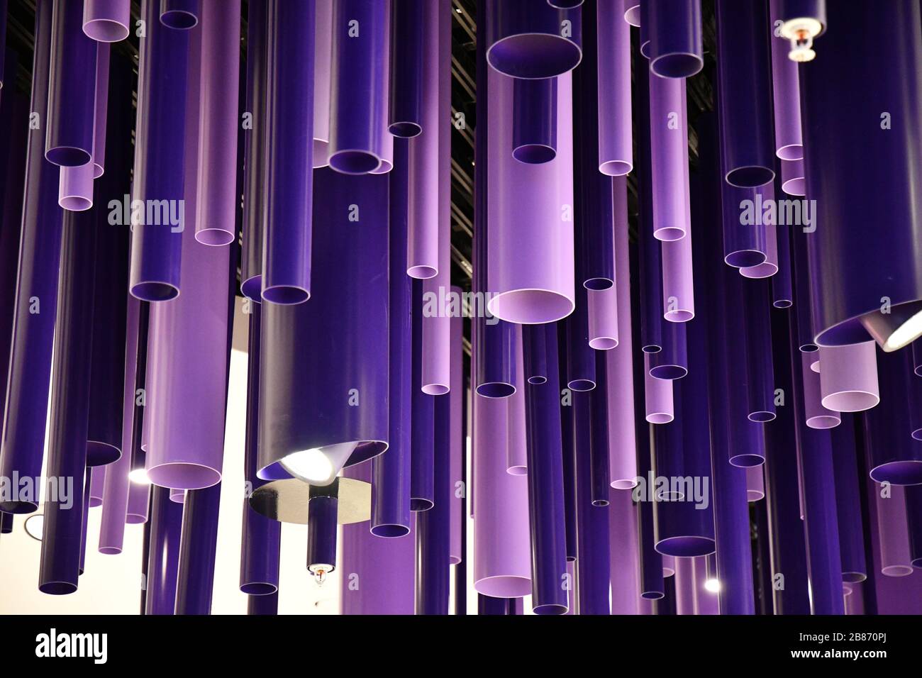 Lignes géométriques arrière-plan abstrait. Tuyaux de cylindre bleu violet de différents diamètres. Décorations suspendues inhabituelles. Motif de couleur violet. Créativité Banque D'Images