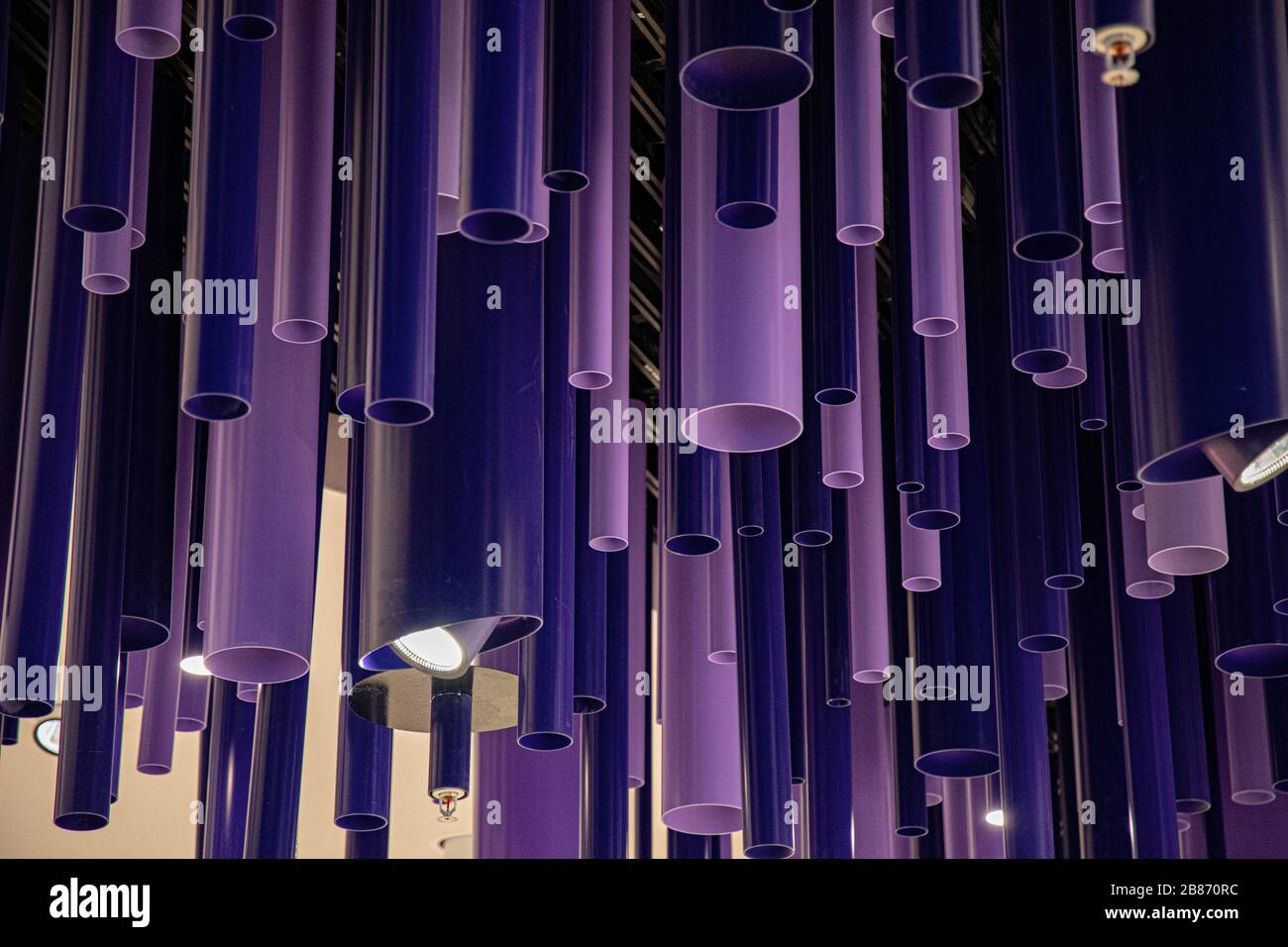 Arrière-plan géométrique abstrait. Tuyaux de cylindre violet et bleu de longueurs et de diamètres différents. Décorations inhabituelles faites de tuyaux en plastique closeup. Banque D'Images