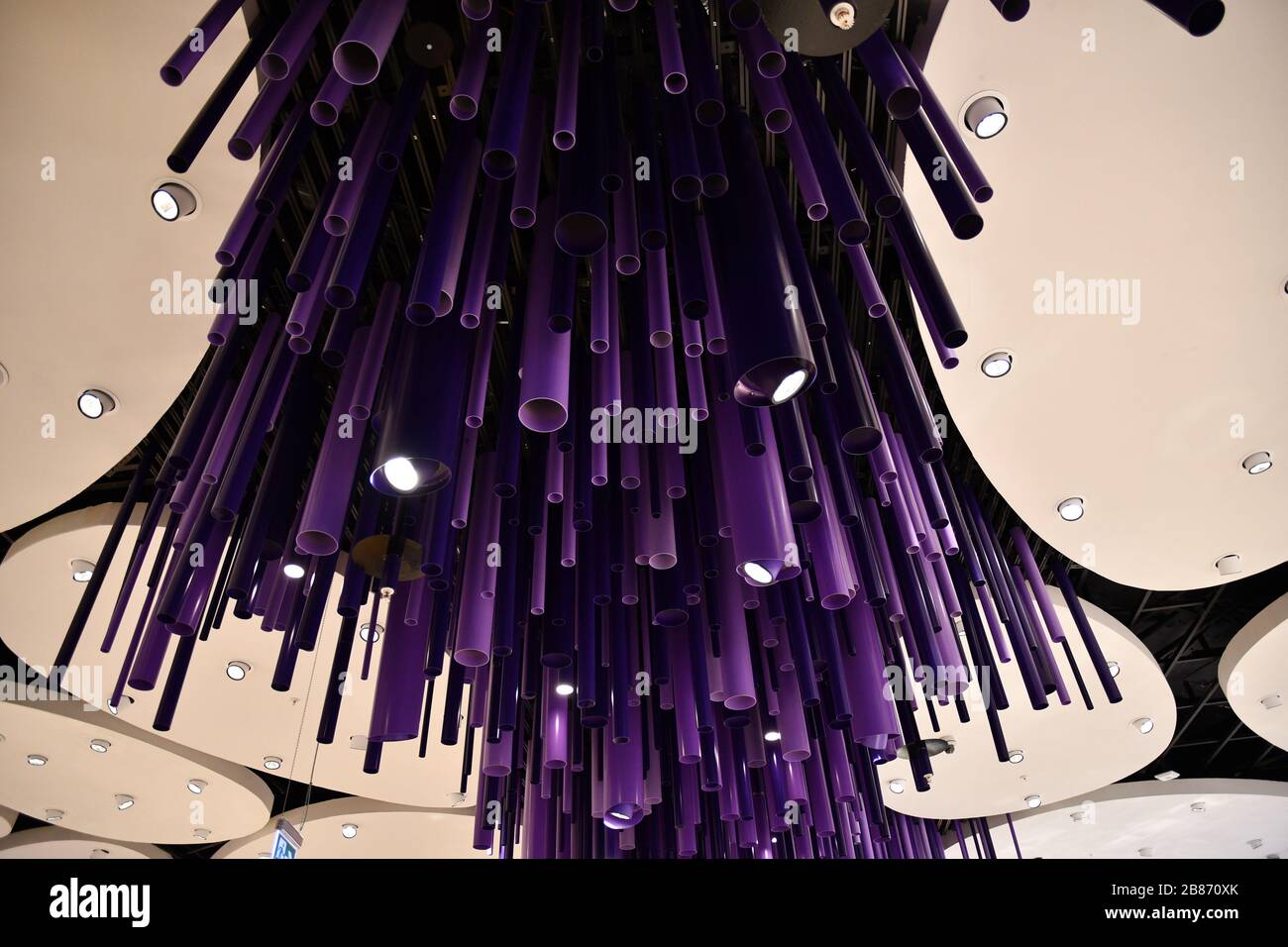 Tuyaux violet foncé et formes d'ellipse blanches. Arrière-plan abstrait de formes et de lignes géométriques. Equipement d'éclairage créatif au plafond. Futuriste Banque D'Images