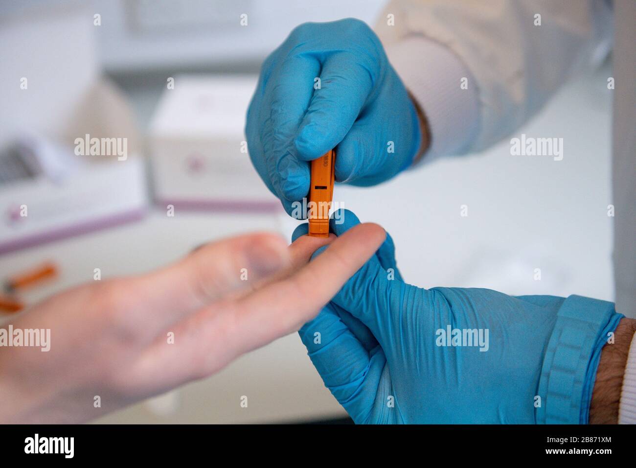 Le sang capillaire est prélevé du bout des doigts lors d'une démonstration à Surescreen Diagnostics, basée à Derby, d'un test qu'ils ont fabriqué qui prétend être de 98% précis pour déterminer si une personne est infectée par le coronavirus, coûte 6 £ et peut être utilisé en 10 minutes. Banque D'Images