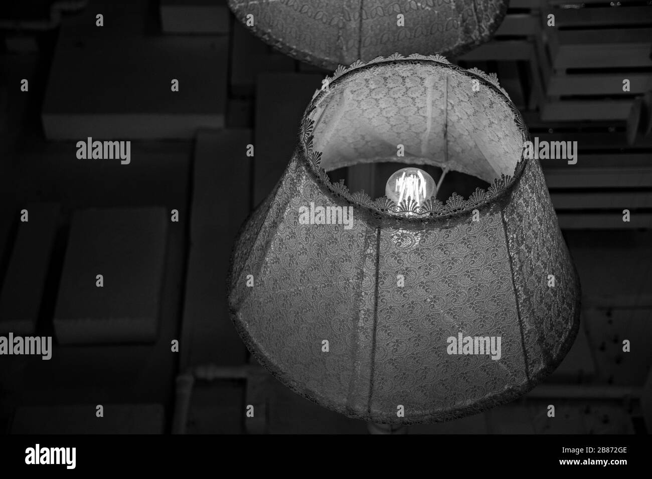 Lustre de style rustique avec abat-jour en textile vintage et filament brillant à l'intérieur d'une ampoule en verre. Lampe chic et délabeur. Lampe rétro décorée de dentelle tressée. Banque D'Images