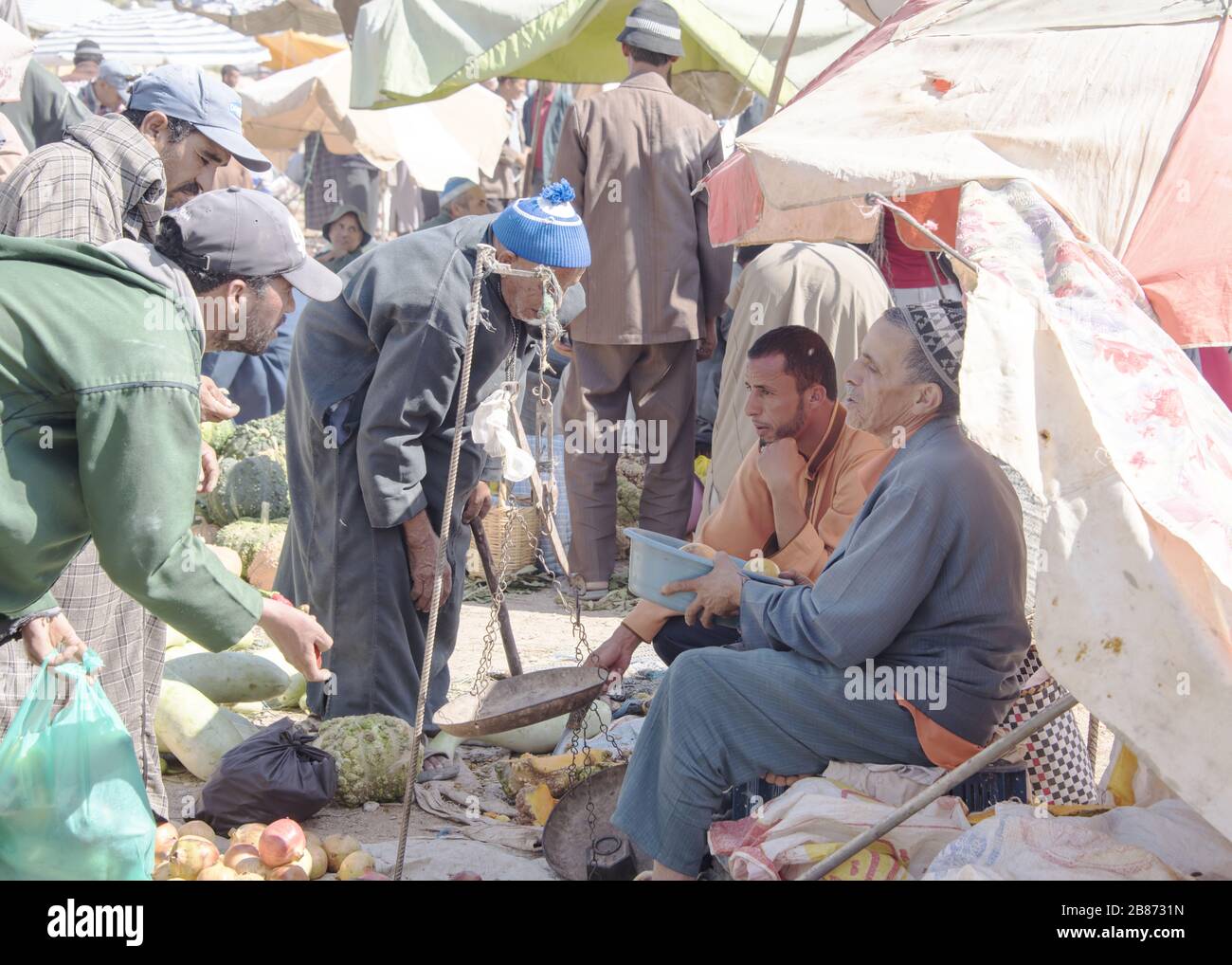 Essouria, Maroc - septembre 2017: Un agriculteur siège en servnig pour vendre ses produits sur le marché ouvert hebdomadaire berber à l'extérieur d'Essaouira au Maroc. Les femmes Banque D'Images