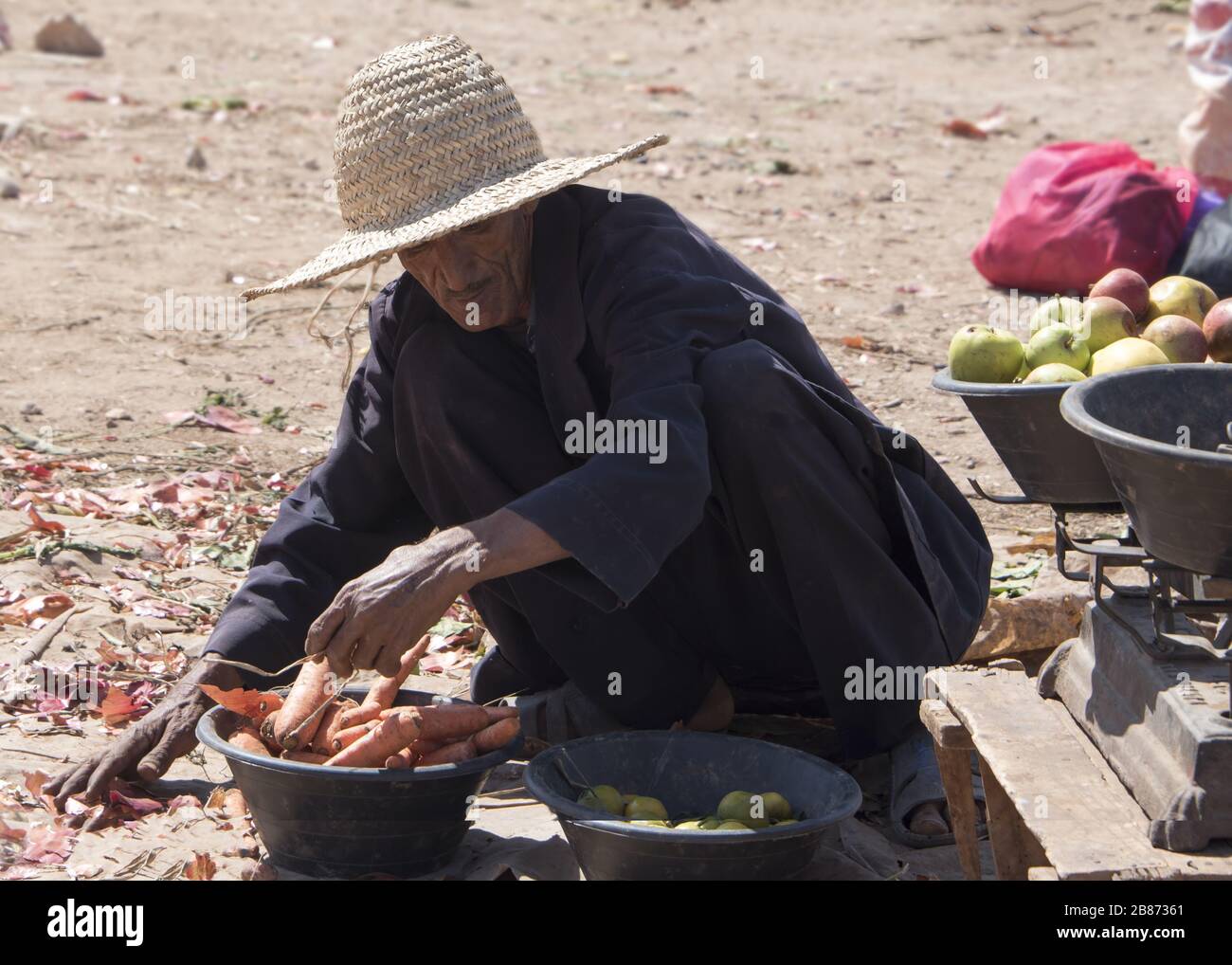 Essouria, Maroc - septembre 2017: Un agriculteur trie ses produits restants à la fin du marché berbère local Banque D'Images