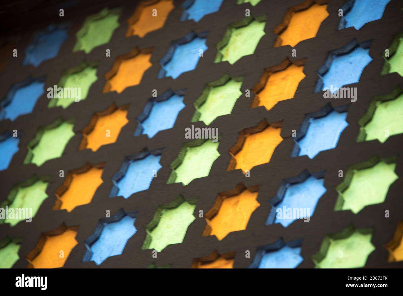 Essouria, Maroc - septembre 2017 : écran en verre bleu, vert et jaune coloré dans des motifs géométriques traditionnels dans un ancien Banque D'Images