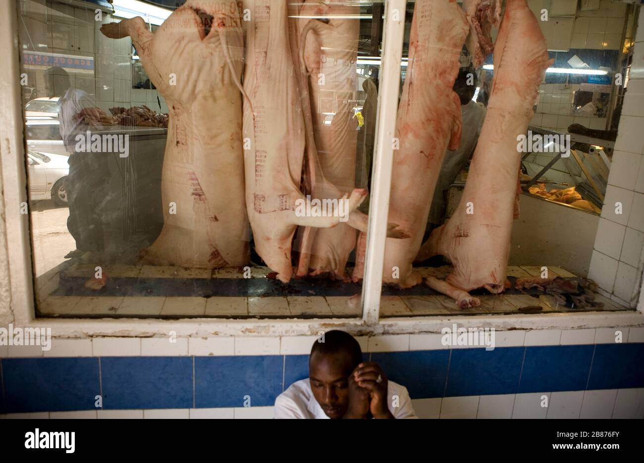 Un boucher prend une pause au marché municipal de Nairobi au Kenya le 10 mars 2011. Banque D'Images