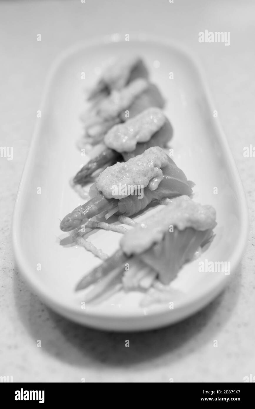Saumon roulé avec asperges et concombres frais garnis de sauce aux crevettes sur le dessus Banque D'Images