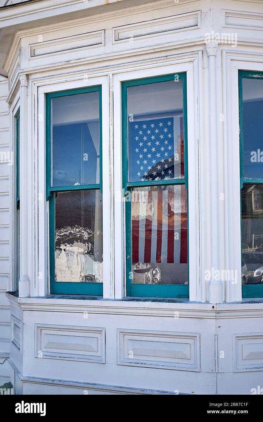 Le patriotisme brille à travers le verre de fenêtre d'une maison dans Pacific Grove. Banque D'Images