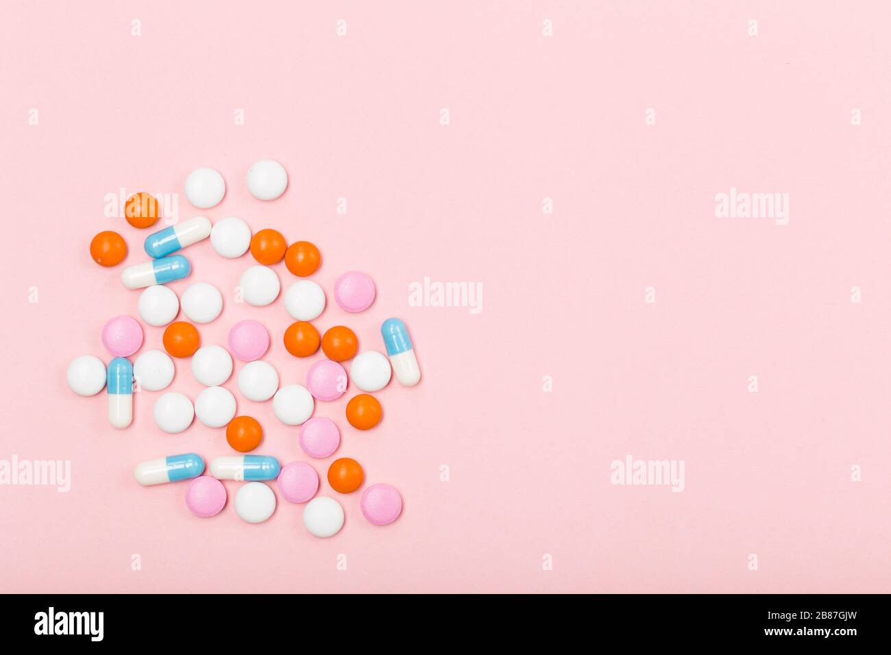 Assortiment de pilules, comprimés et capsules de médecine pharmaceutique sur fond rose. Espace libre. Concept de santé. Banque D'Images