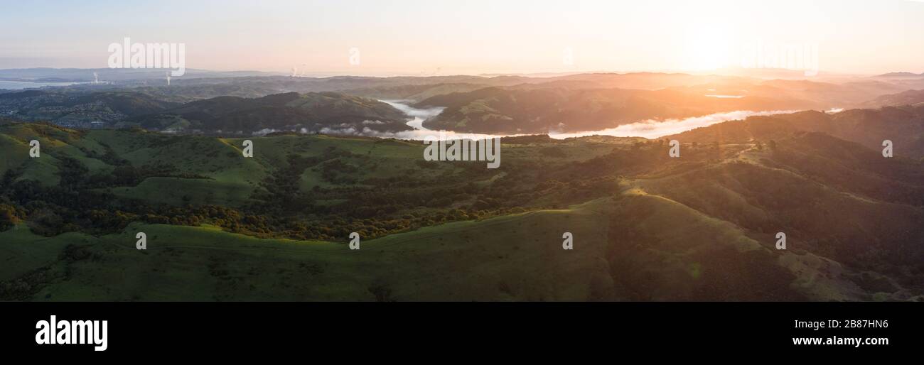 La lumière du soleil du matin brille sur les collines vertes de la baie East Bay dans le nord de la Californie. Cette zone ouverte, à l'est de San Francisco, est verte en hiver. Banque D'Images