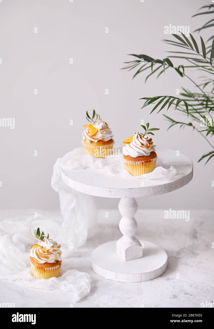 Cupcakes faits maison décorés de citron et de feuilles sur fond blanc. Espace libre pour votre texte Banque D'Images