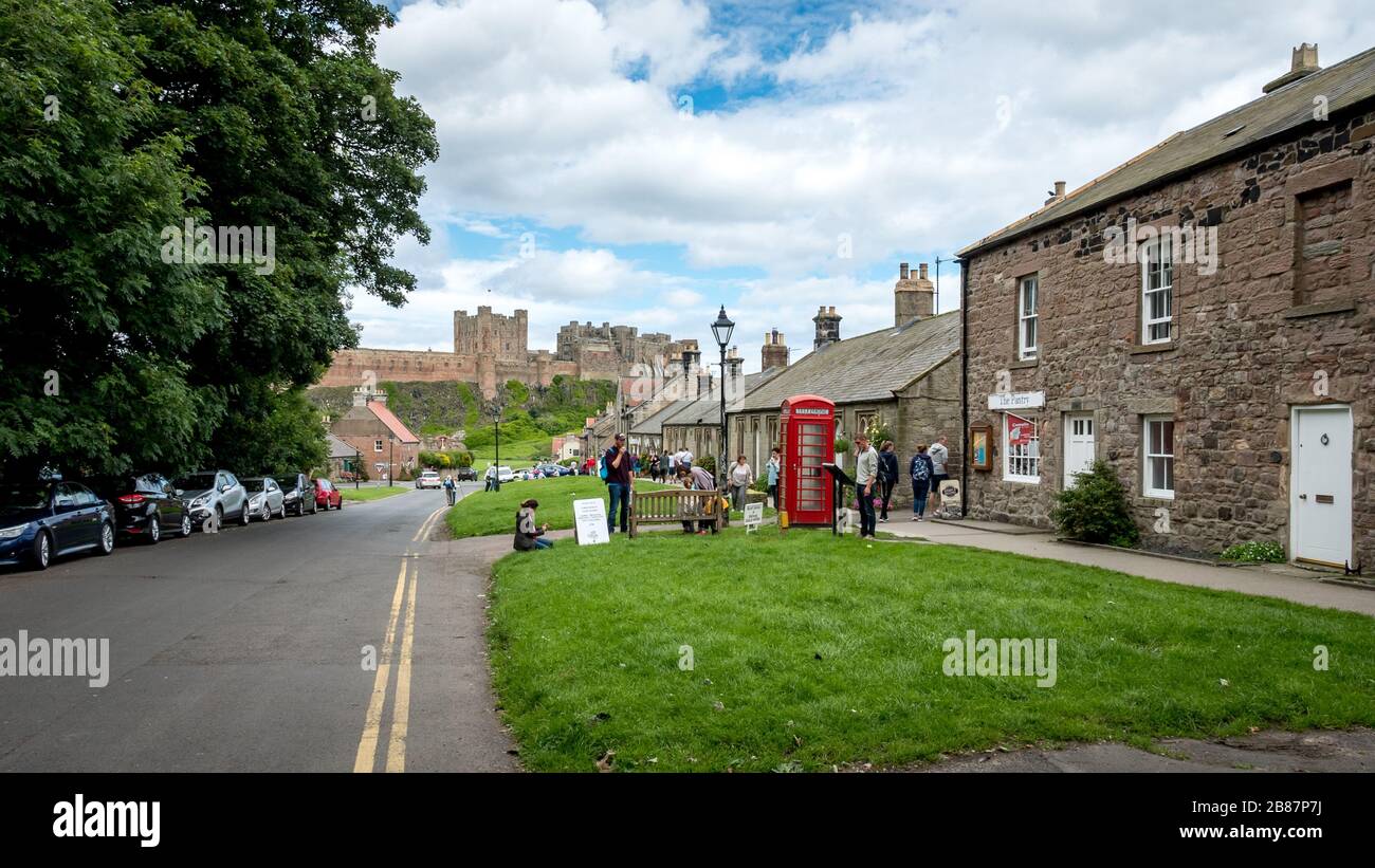 Village et château de Bamburgh, Northumberland, Angleterre. Les touristes se cachant dans les rues pittoresques de la ville populaire du nord-est de l'Angleterre. Banque D'Images