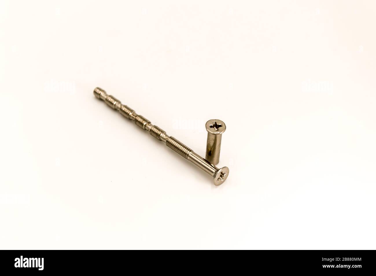 Visser et sa douille de poignée de porte métallique sur un fond blanc Banque D'Images Visser et sa douille de poignée de porte métallique sur un fond blanc Banque D'Images