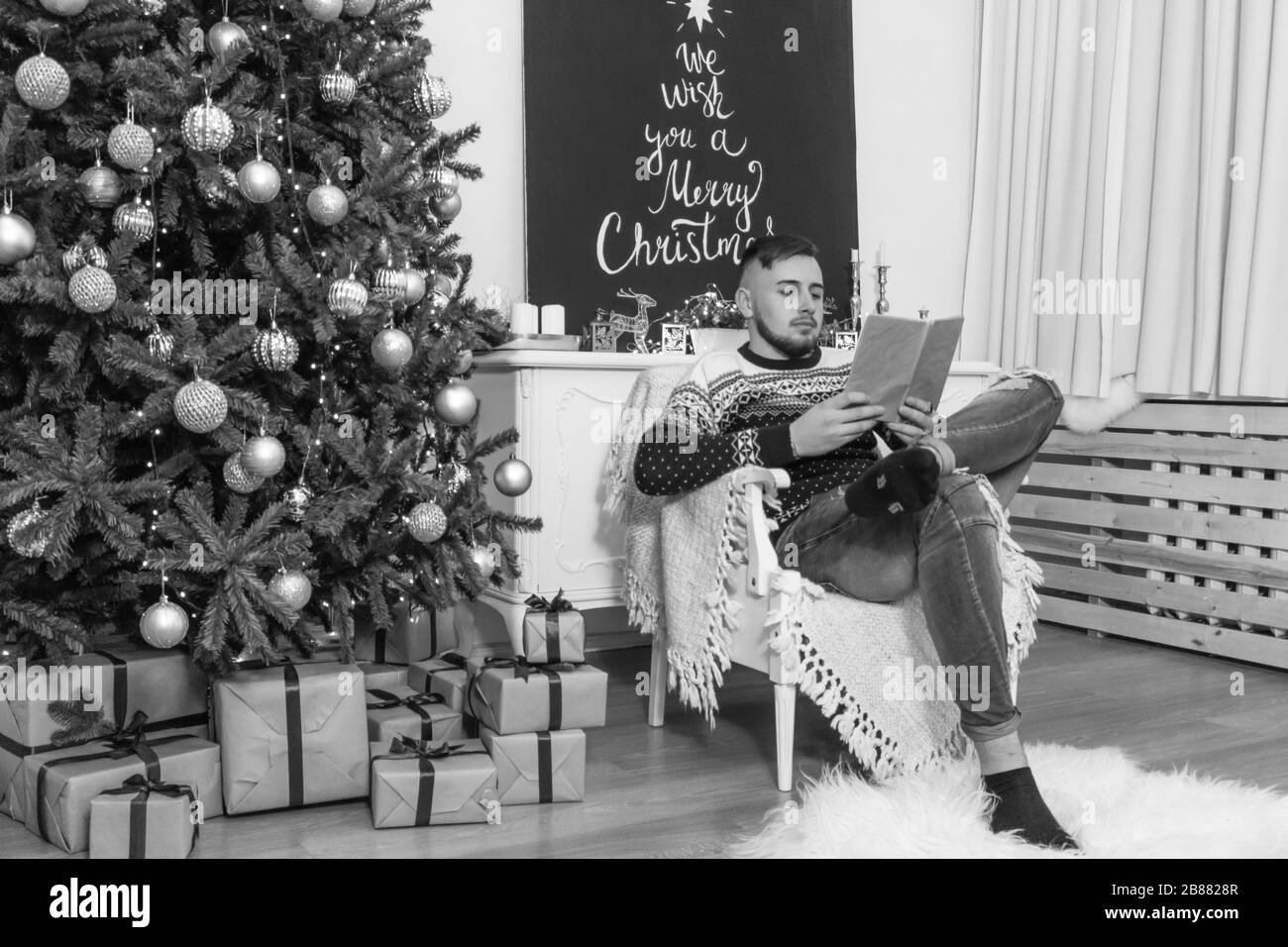 L'homme lit le livre dans la photo de la salle de Noël Banque D'Images