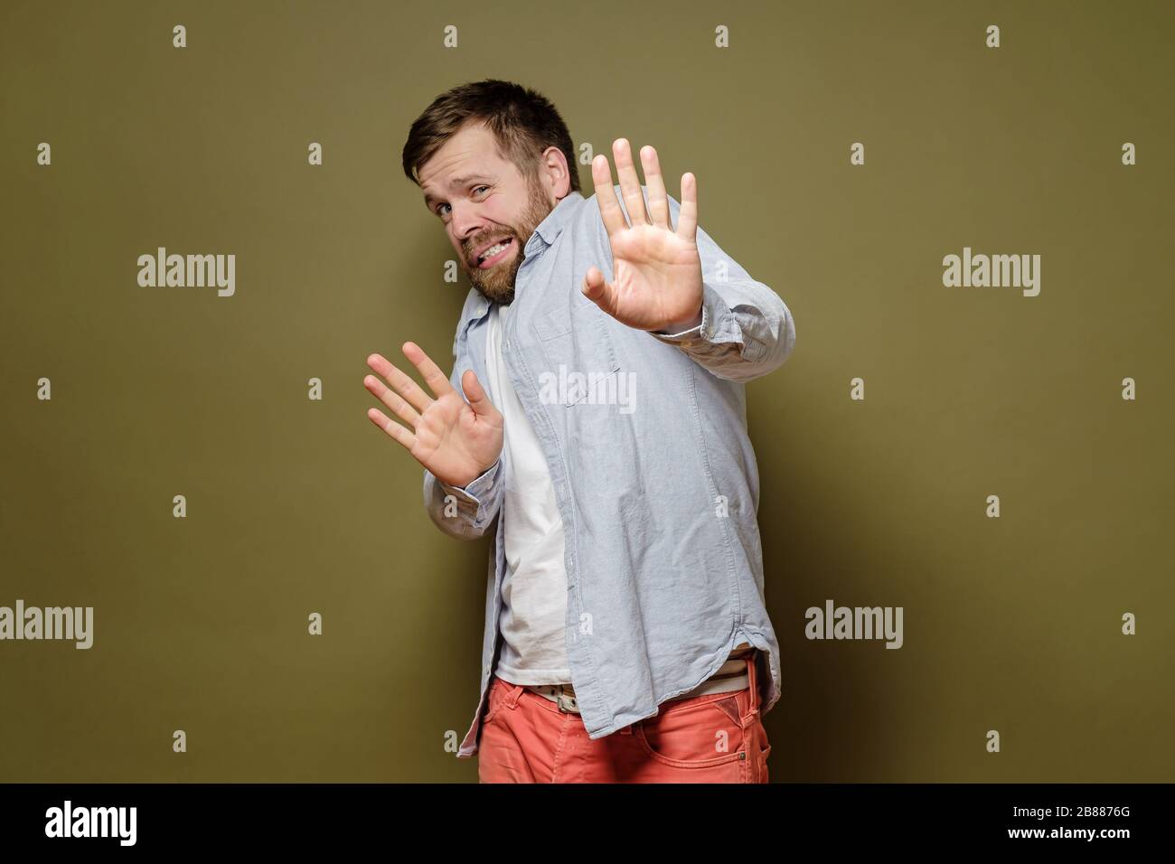 L'homme effrayé a peur d'obtenir le virus, il fait un geste d'arrêt avec les mains et regarde avec dégoût. Concept de santé. Banque D'Images