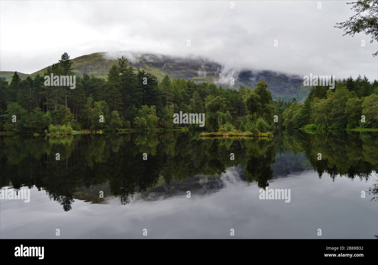 Réflexions à Glencoe lochan en une journée brumeuse, dans les Highlands écossais, en Écosse Banque D'Images
