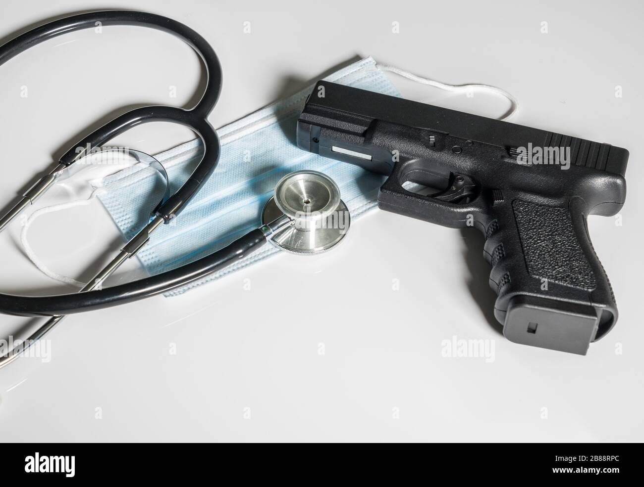 Pistolet pistolet posé sur le masque médical en concept pour les dangers auxquels fait face le personnel médical de première ligne Banque D'Images