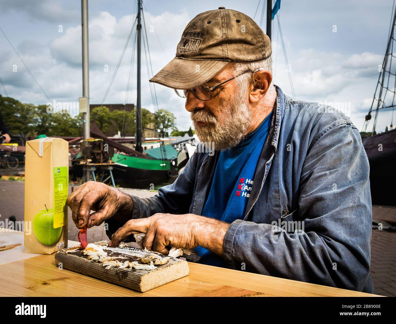 Amsterdam, septembre 2018 - Portrait d'un ancien travailleur qui mangeait du hareng traditionnel avec des mains recouvertes d'huile. Ce monsieur travaillait probablement à sili Banque D'Images