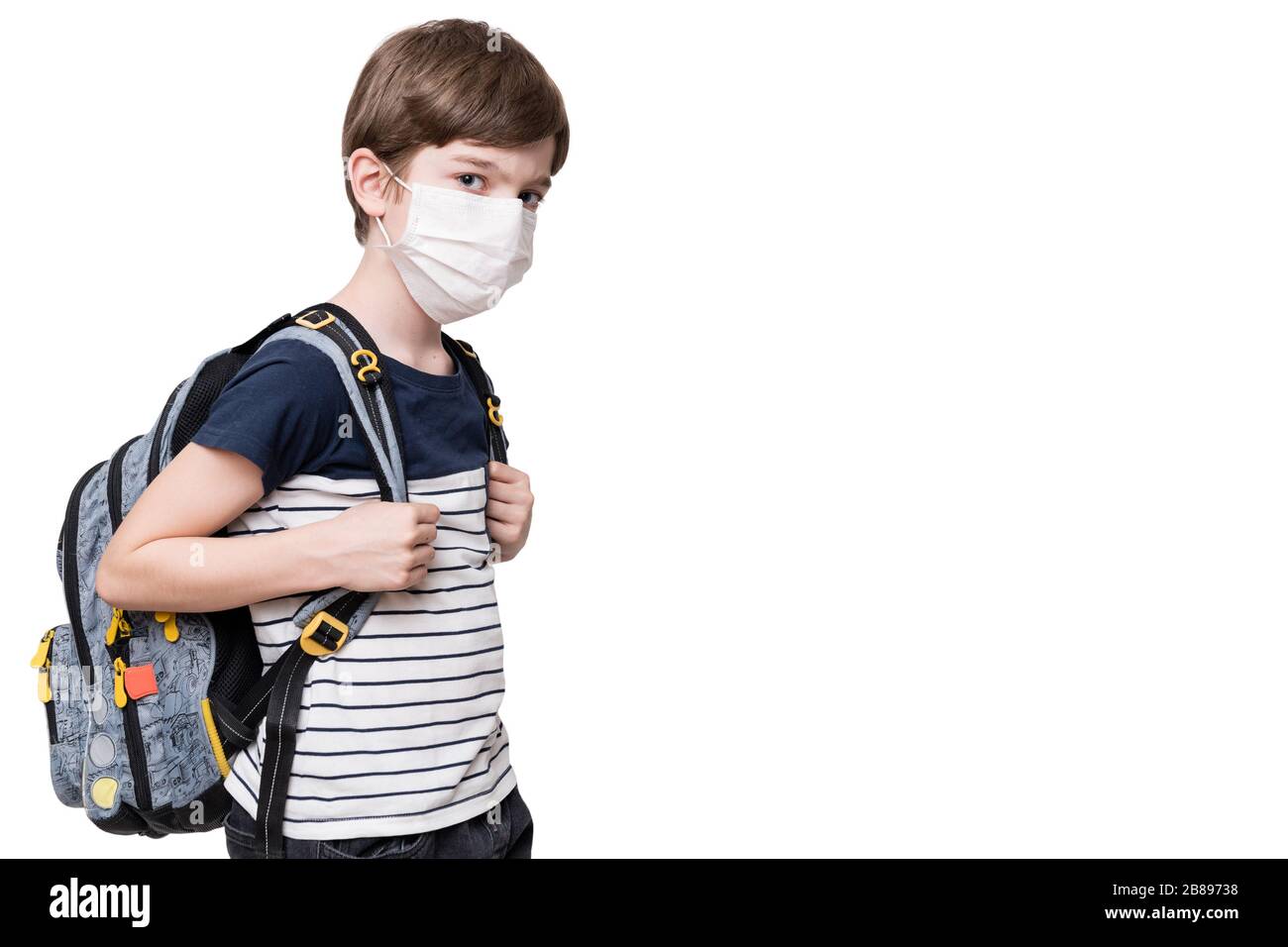 Portrait d'un enfant avec masque de visage tenant le sac scolaire, isolé sur fond blanc Banque D'Images