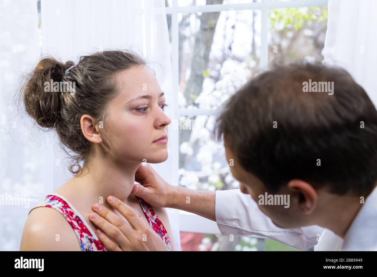 Médecin inspectant, faisant un examen de palpation de la jeune femme avec la maladie de grave hyperthyroïdie symptômes de la glande thyroïde élargie goitre et ophth Banque D'Images