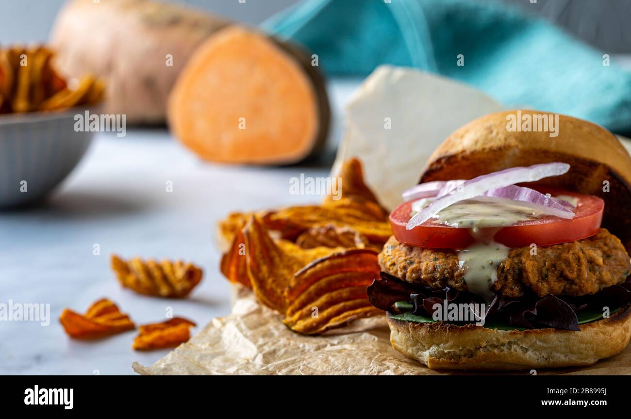 Hamburger aux pois chiches végétaliens avec des chips de pommes de terre douces. Banque D'Images
