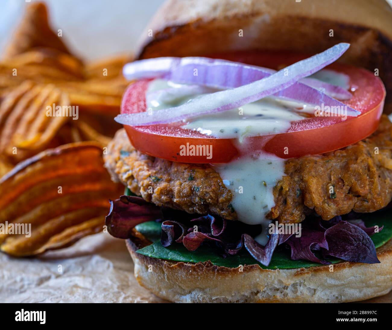 Hamburger aux pois chiches végétaliens avec des chips de pommes de terre douces. Banque D'Images