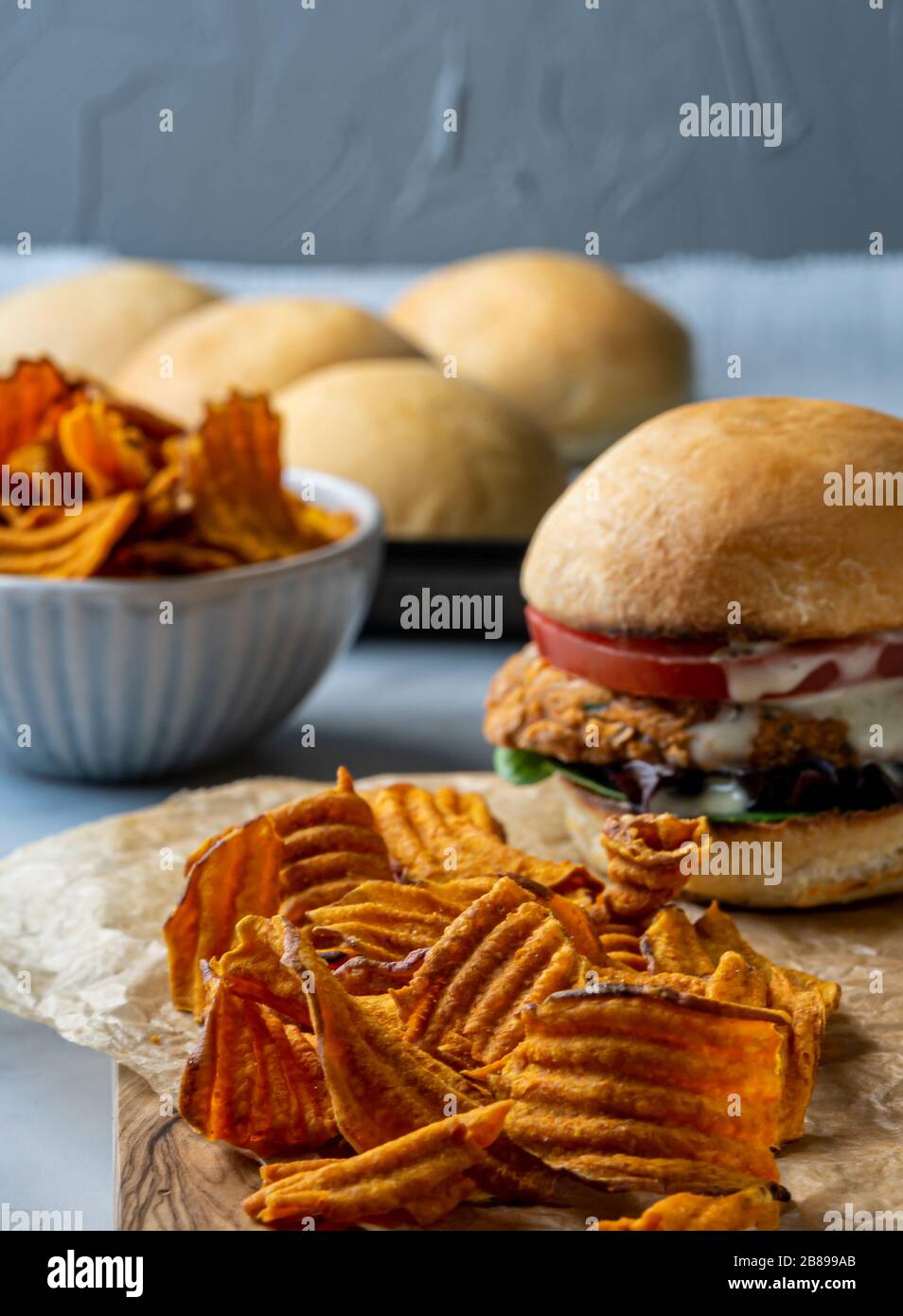 Hamburger aux pois chiches végétaliens avec des chips de pommes de terre douces. Banque D'Images