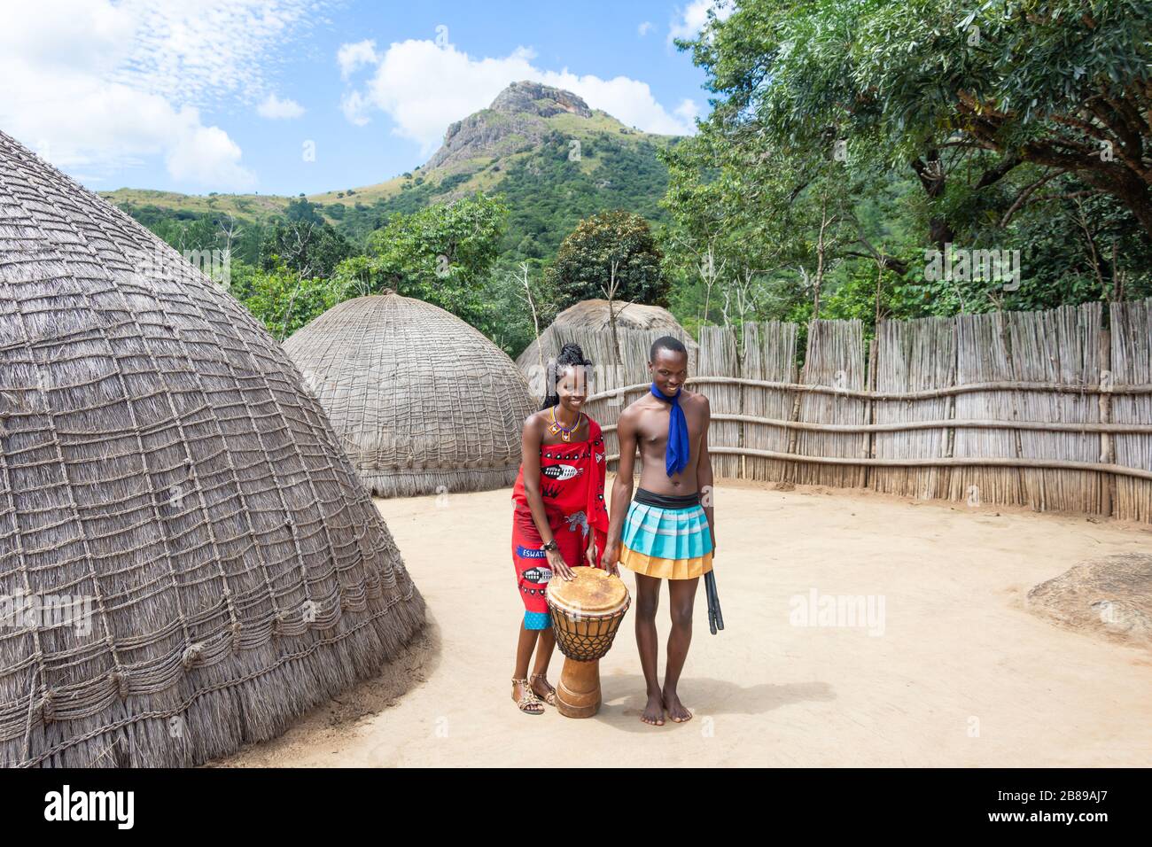 Couple par maisons de ruches au Centre culturel du Swaziland, réserve naturelle de Mantenga, Lobamba, Vallée d'Ezulwini, Royaume d'Eswatini (Swaziland) Banque D'Images
