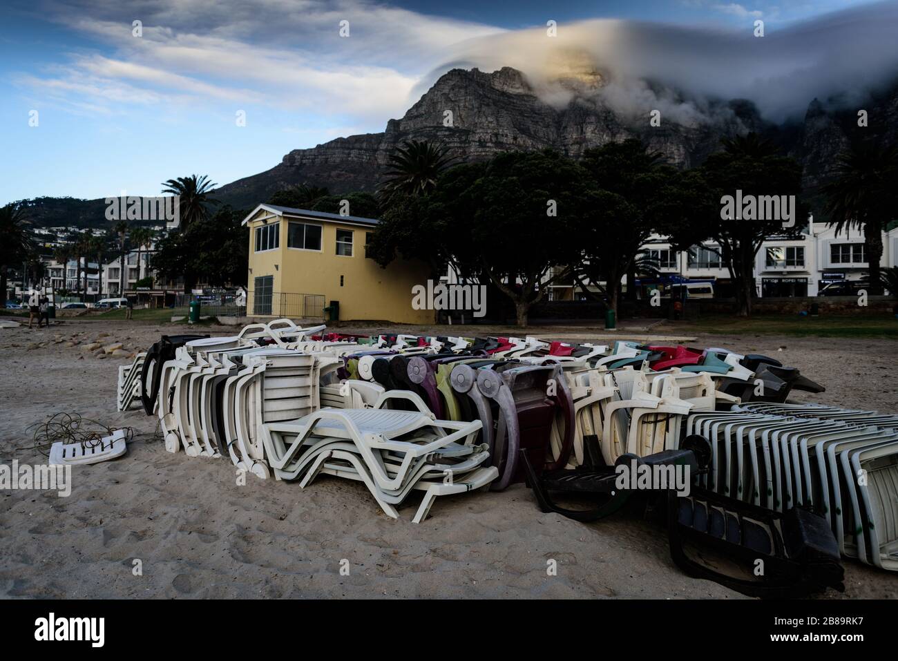 Les meubles de plage sont empilés et stockés sur la plage de Camp Bay au Cap lors de l'épidémie mondiale de Cornavirus en Afrique du Sud Banque D'Images