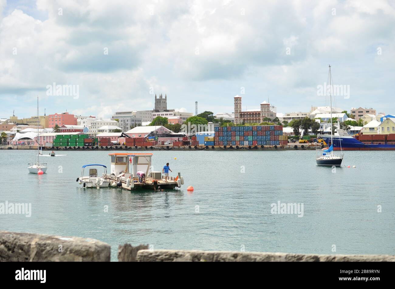 Hamilton Cargo Docks avec conteneurs empilés côté eau. Industrie de la navigation commerciale. Petits bateaux dans la baie avec des quais de chargement à l'arrière. Banque D'Images