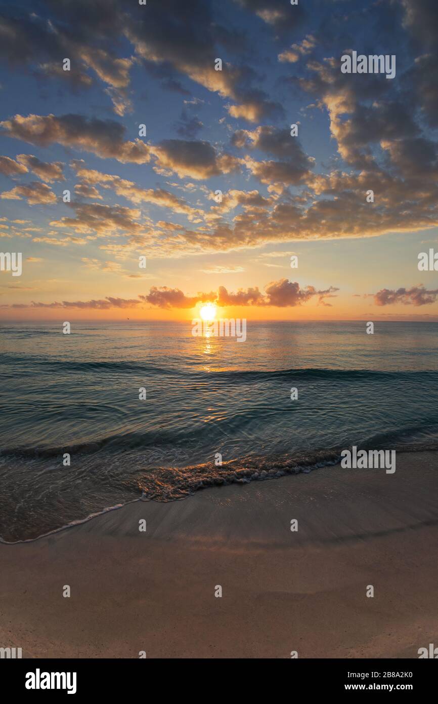 Magnifique lever de soleil au bord des plages de sable de la Riviera Maya à Cancun, au Mexique, avec des reflets dorés sur la mer des Caraïbes. Banque D'Images