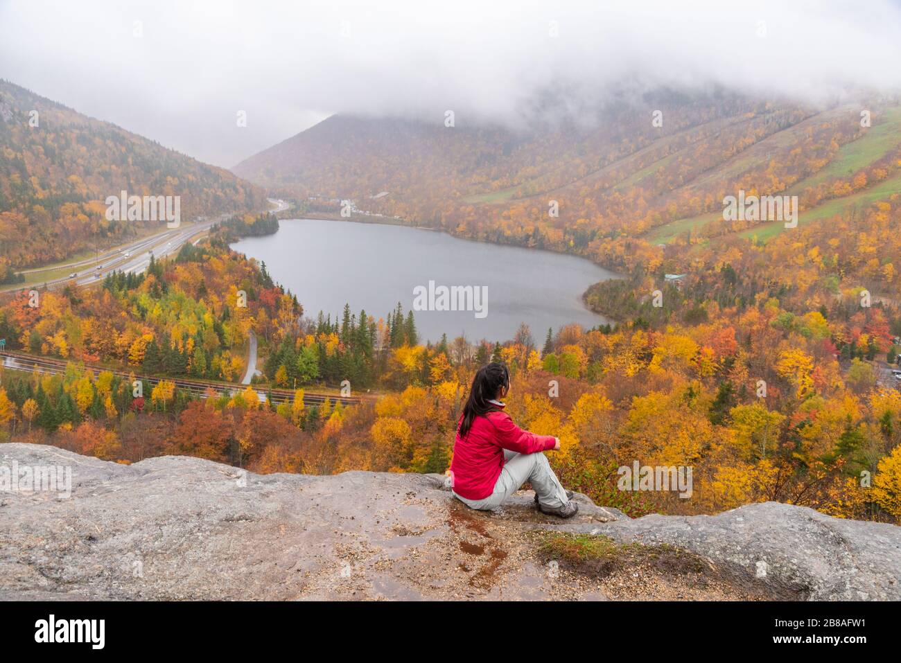 Femme se posant devant le magnifique lac Echo de Artists Bluff Loop dans le New Hampshire USA Banque D'Images