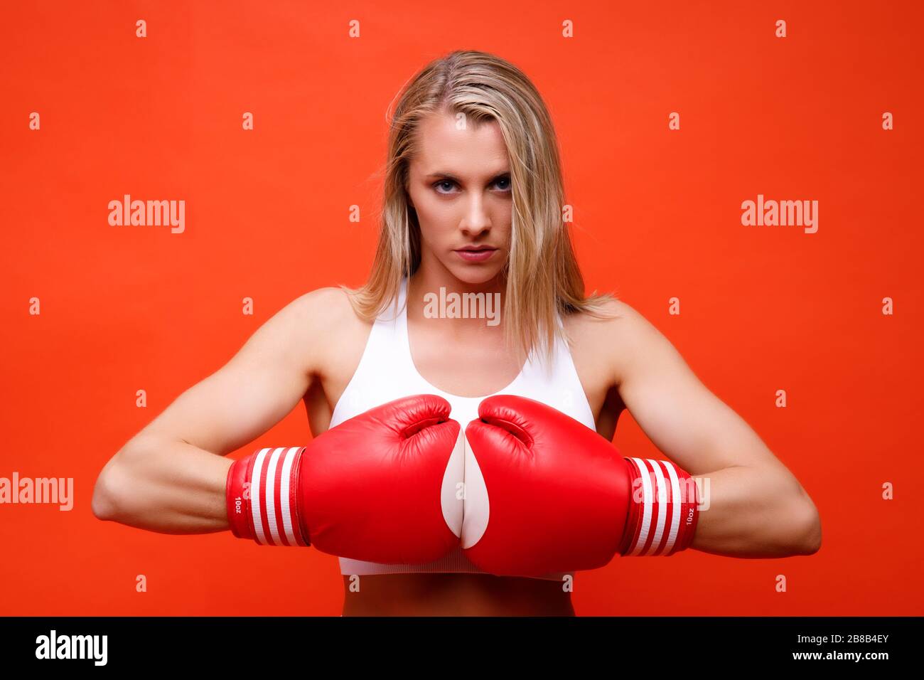 Athlète féminin posant avec des gants de boxe Banque D'Images