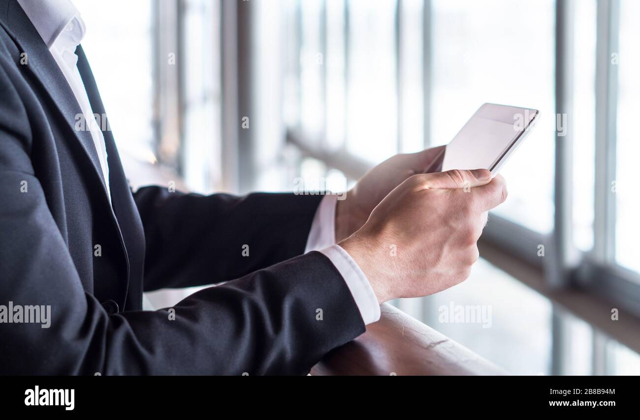 Homme d'affaires utilisant une tablette ou lire des nouvelles avec une tablette. Homme d'affaires travaillant dans un immeuble de bureaux moderne avec un appareil mobile intelligent. Banque D'Images