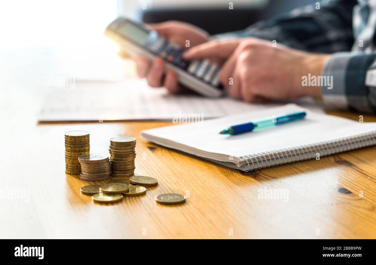 Homme planifiant la finance familiale et utilisant la calculatrice. Compte des économies, du budget, des taxes, des dépenses et du coût de la vie. Calcul de l'argent. Comptable travaillant. Banque D'Images