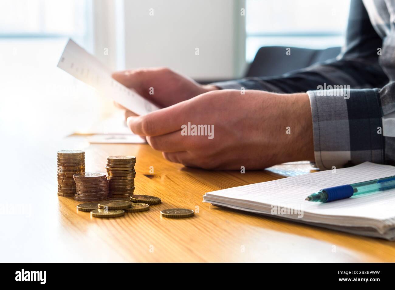 Homme lisant un relevé bancaire, un rappel de chèque, un document de remboursement d'impôt, une facture de téléphone ou une lettre financière. Concept de prix et de coût de l'assurance habitation ou santé. Banque D'Images