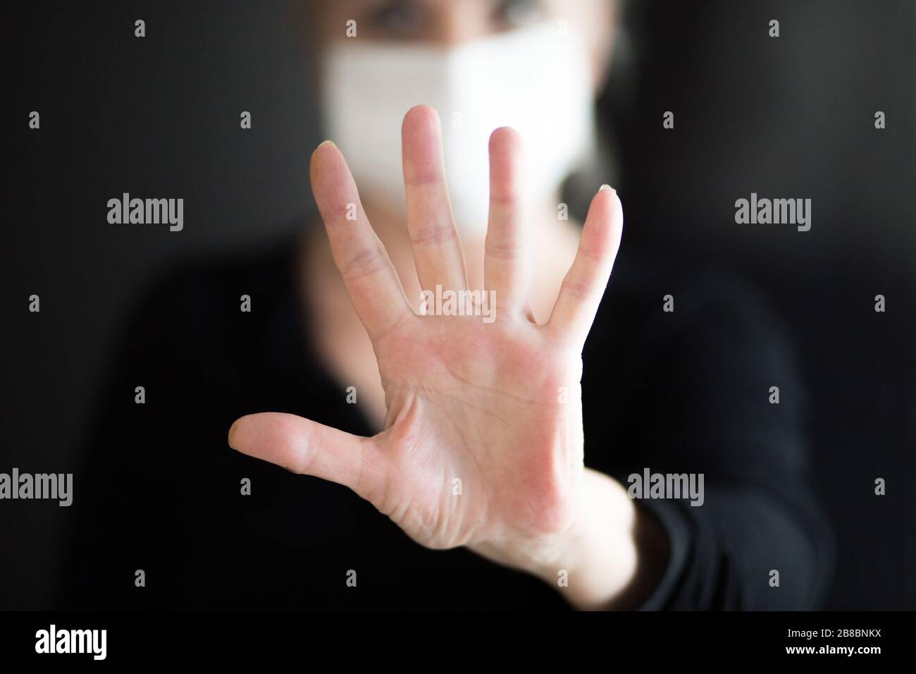 Une femme âgée portant un masque, montre des mains propres et montre un geste d'arrêt des mains pour arrêter l'éclosion du virus corona. Coronavirus et symptômes du virus épidémique. Banque D'Images