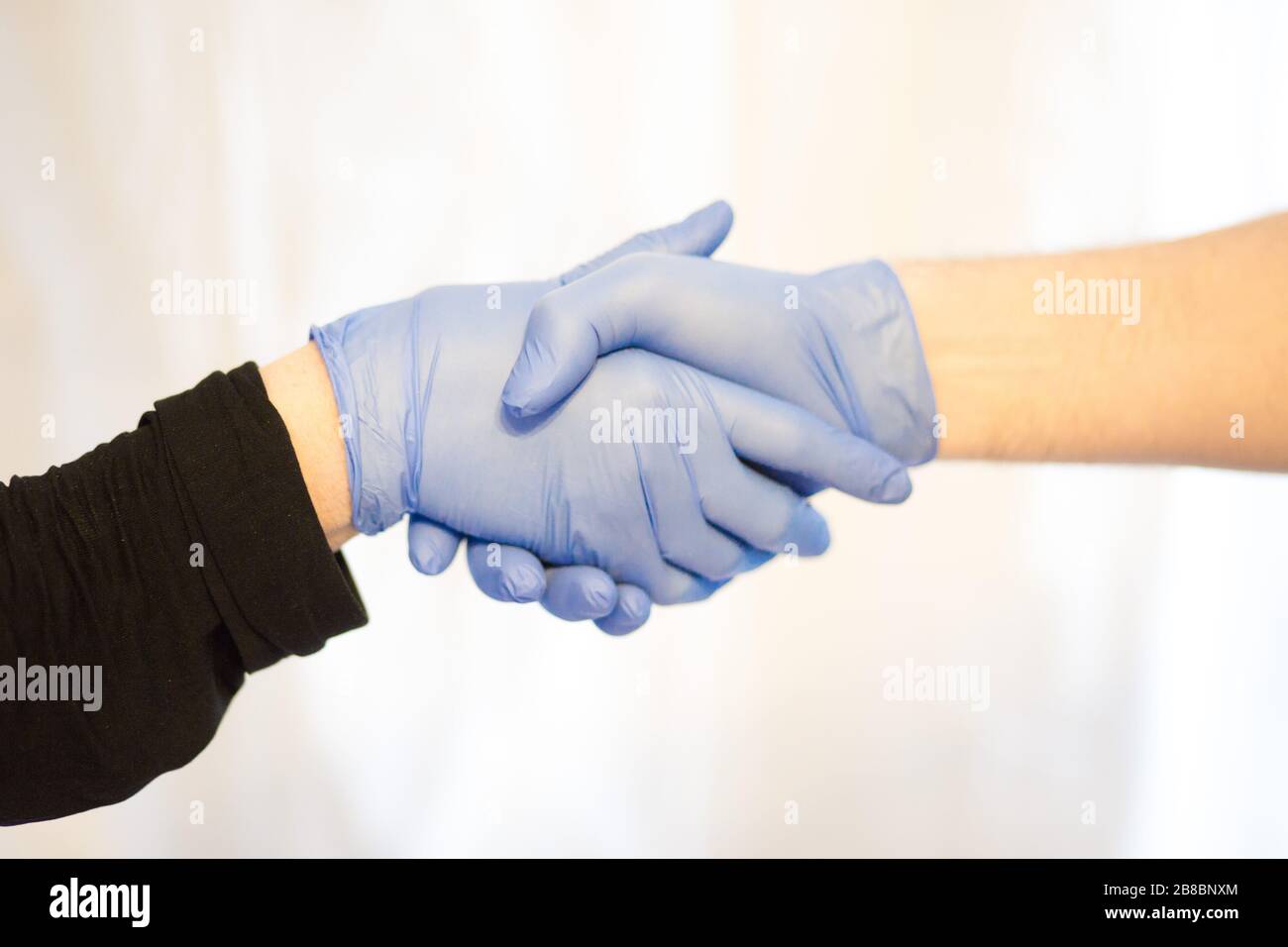 secouer les mains avec des gants pour arrêter l'épidémie de virus corona. Coronavirus et symptômes du virus épidémique. Banque D'Images
