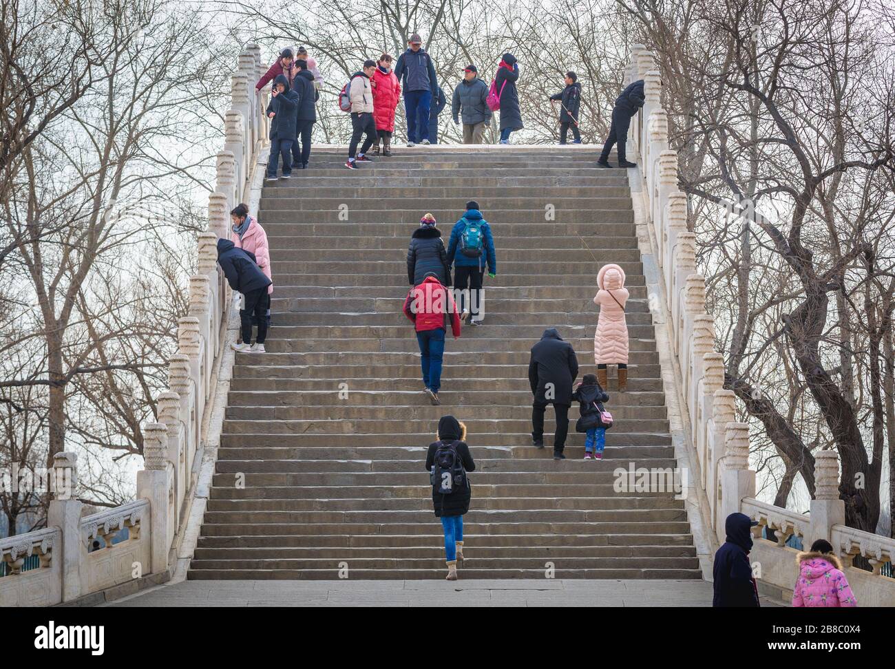 Touristes sur le pont de la ceinture de Jade sur un lac Kunming au Palais d'été, ancien jardin impérial à Beijing, Chine Banque D'Images