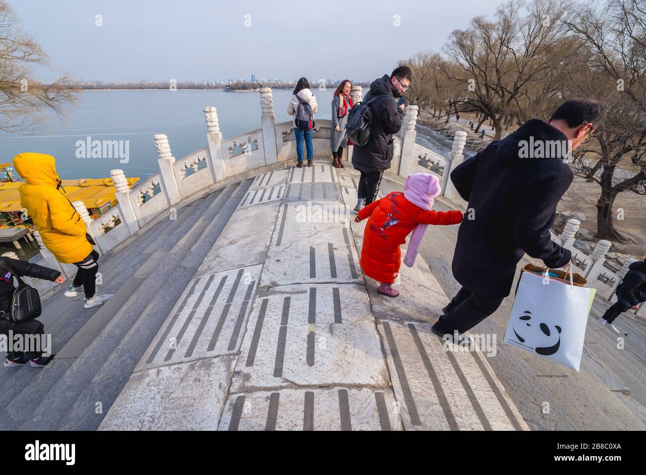 Touristes sur le pont de la ceinture de Jade sur un lac Kunming au Palais d'été, ancien jardin impérial à Beijing, Chine Banque D'Images