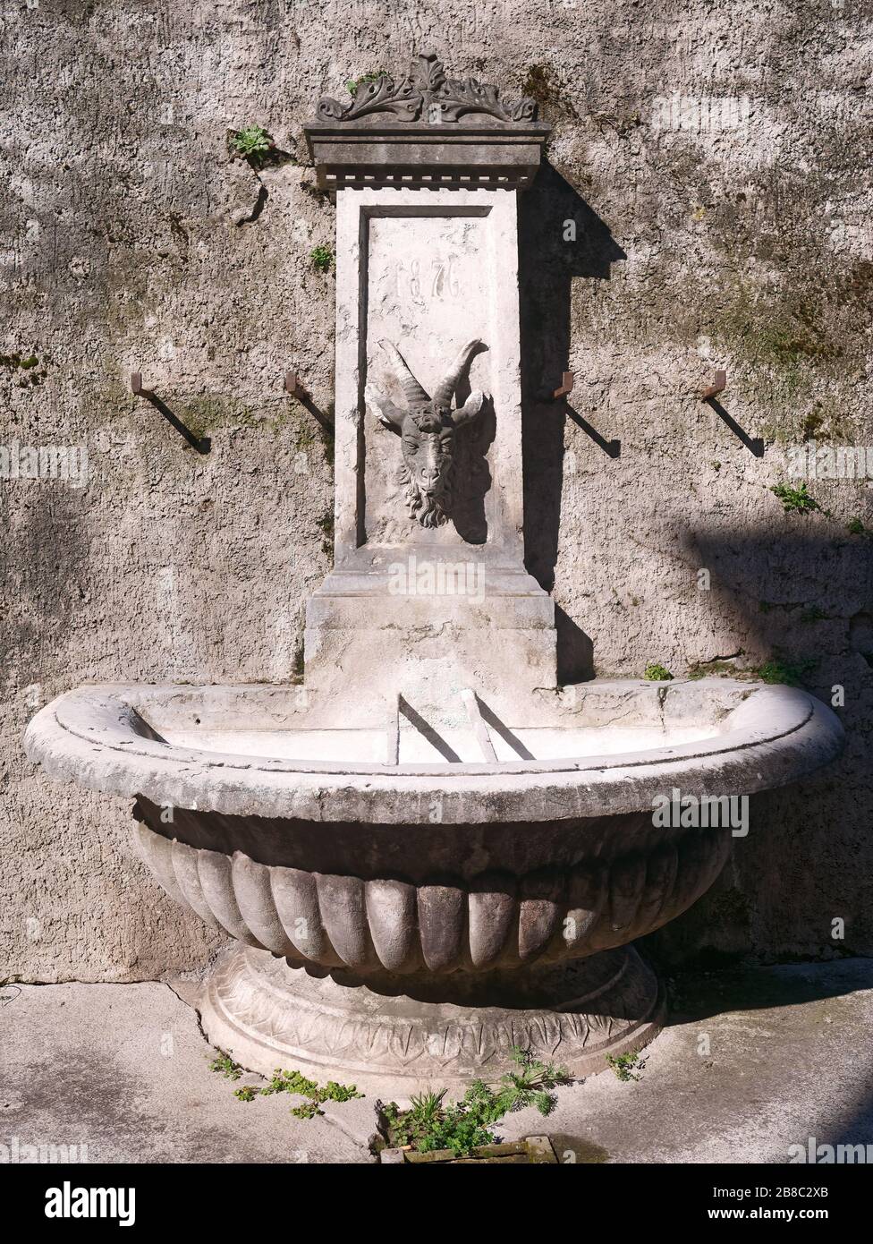 Près de la fontaine d'eau potable du XIXe siècle avec masque en pierre sculpté et bol en coquille de palourdes. Construit en 1876. Banque D'Images