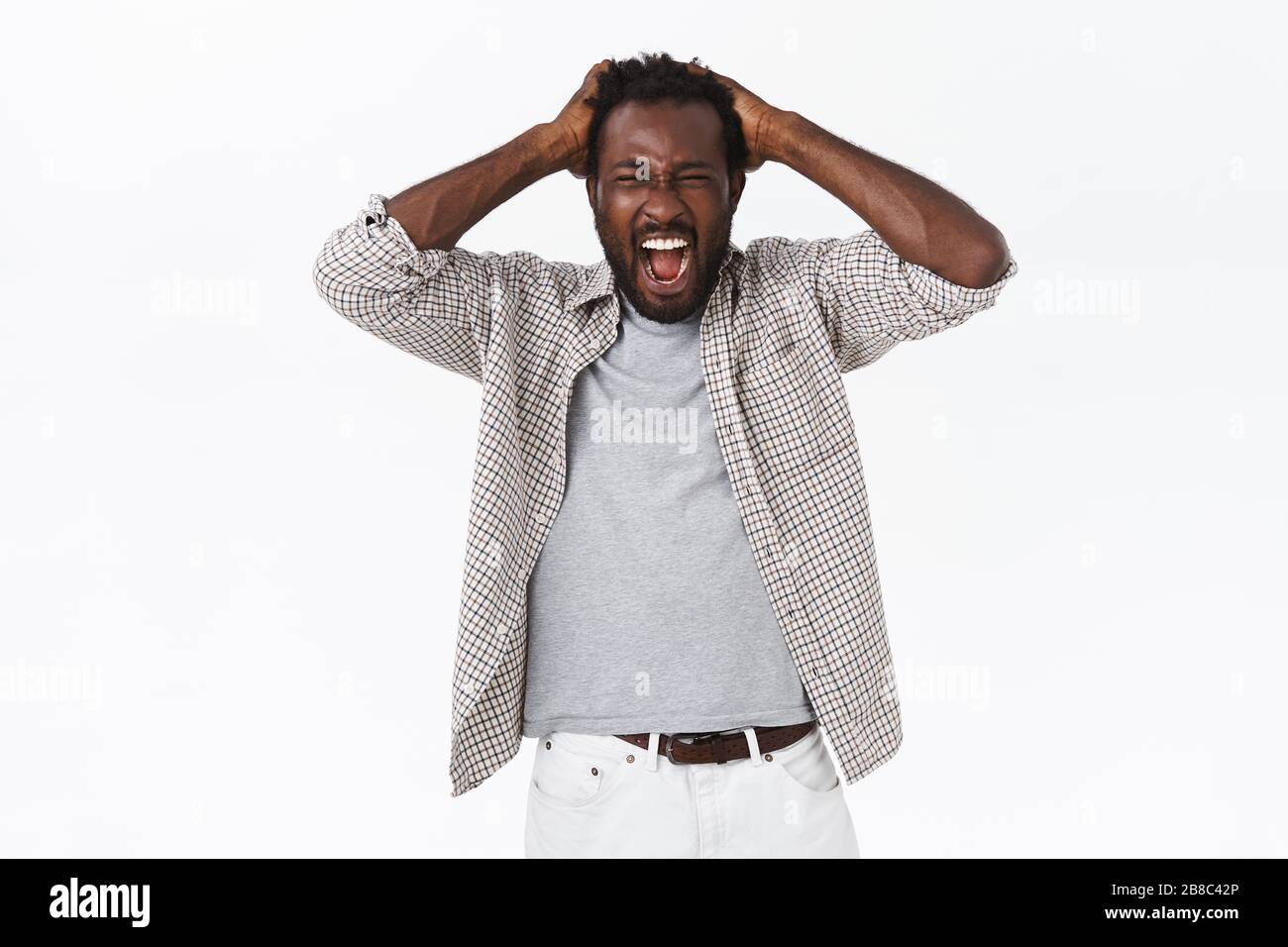 Indigné et affligé, l'homme barbu afro-américain hurla de chagrin et de perte, tenant les mains sur la tête, criant avec des yeux fermés, se sentant Banque D'Images