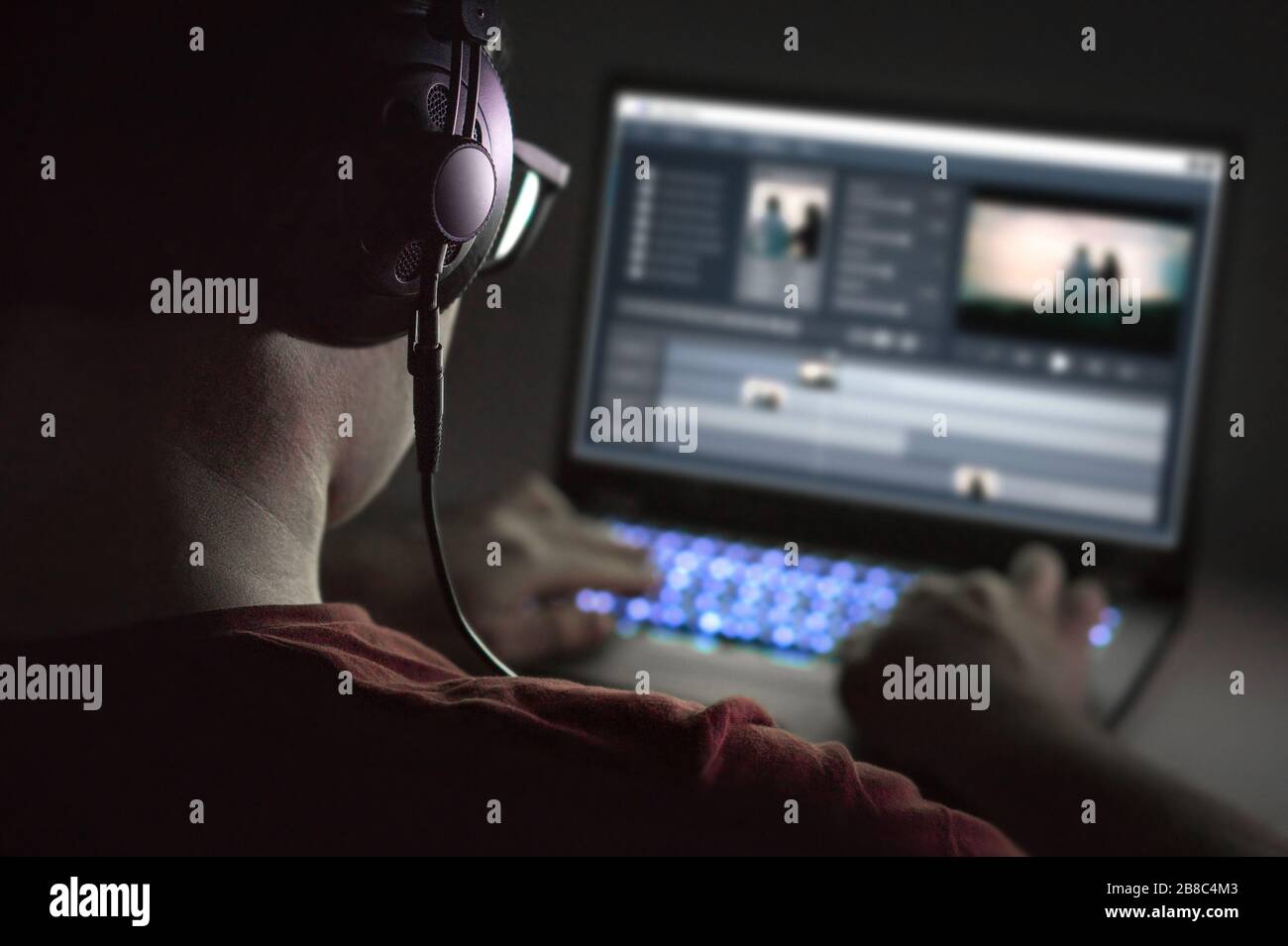 Montage vidéo avec ordinateur portable. Éditeur professionnel ajoutant des effets spéciaux ou des séquences de gradation des couleurs. Vue arrière du jeune homme à l'aide de logiciels informatiques. Banque D'Images