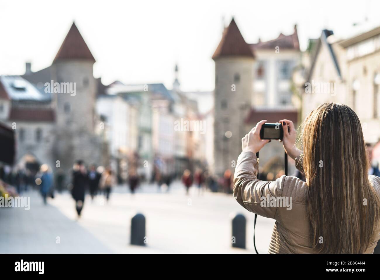 Tourisme à Tallinn prendre la photo de la porte Viru. Femme en vacances en prenant photo du monument en Estonie. Les gens marchant dans la rue populaire. Banque D'Images