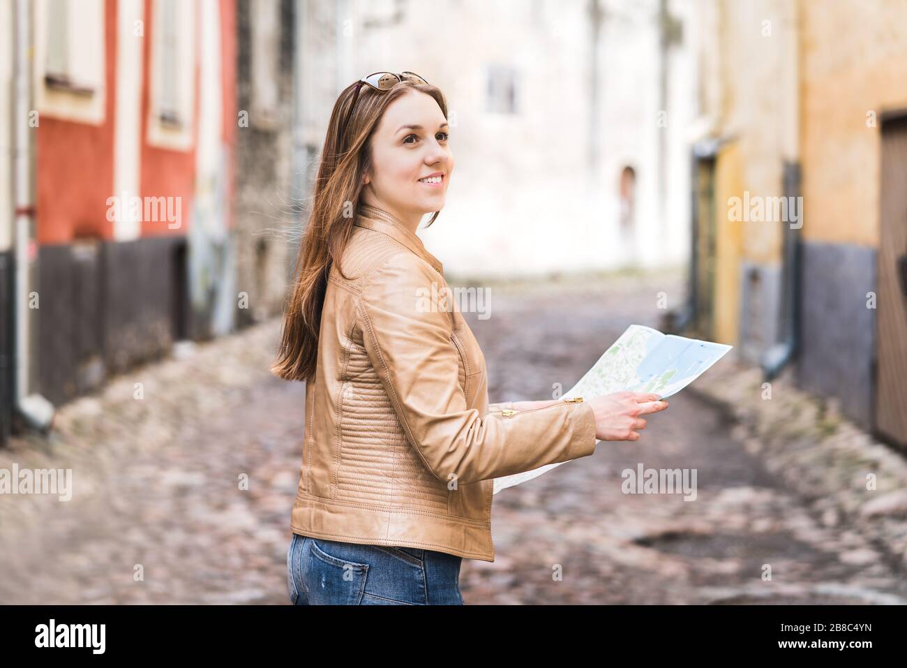 Femme tenant une carte dans la rue de la ville ou la vieille ville. Les femmes touristiques et les voyageurs recherchant la destination pendant les vacances. Voyage, exploration des attractions. Banque D'Images