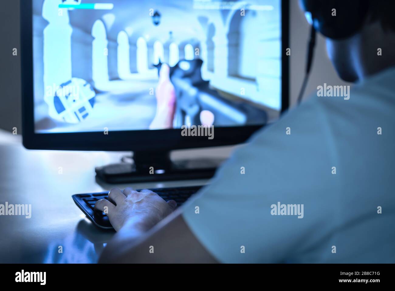 E concept de sport et de jeu. Gamer jouant au jeu vidéo FPS avec ordinateur et portant un casque. Lecteur de jeux vidéo professionnel ou concurrent en cas de panne. Banque D'Images